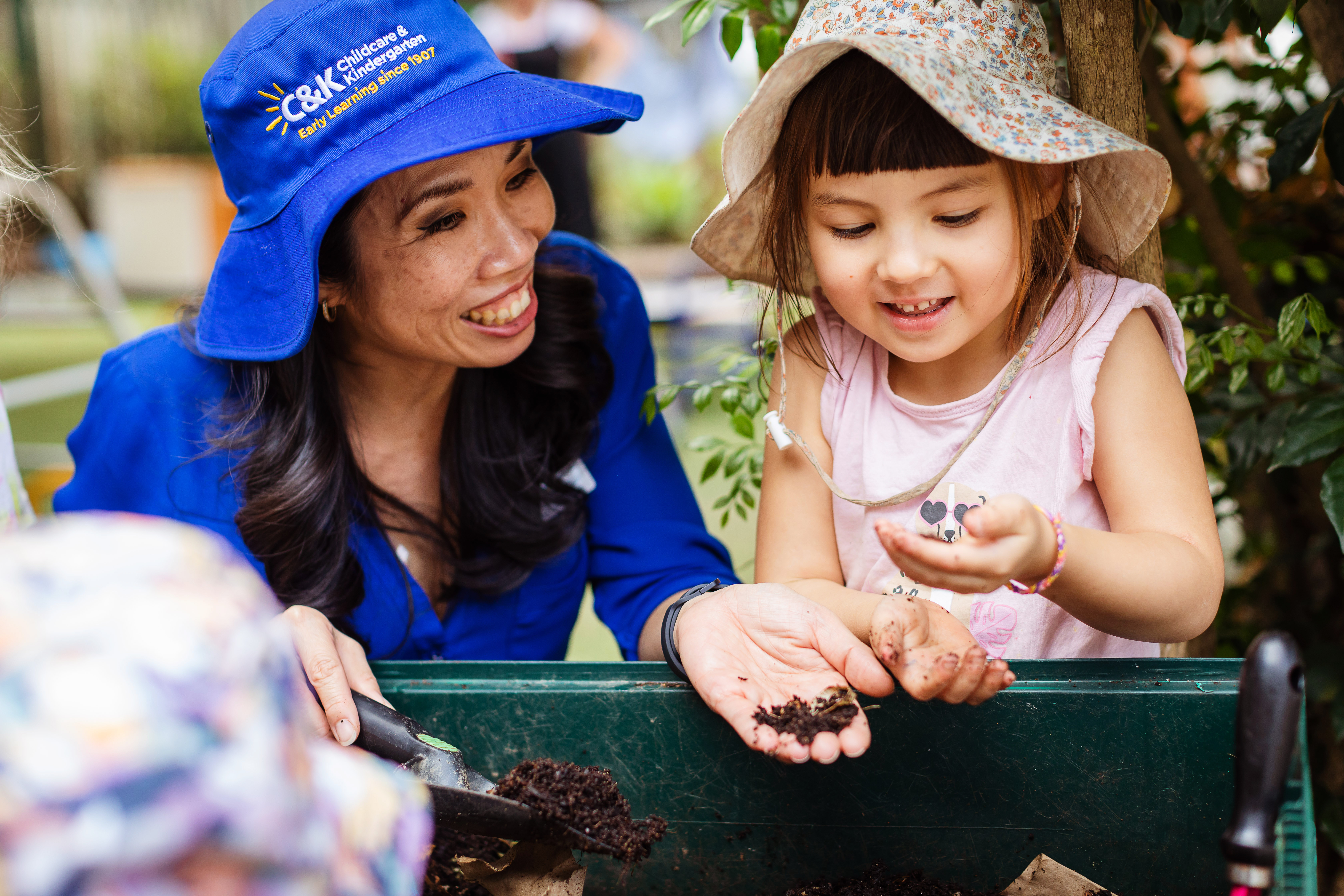 Kindy teacher and child gardening