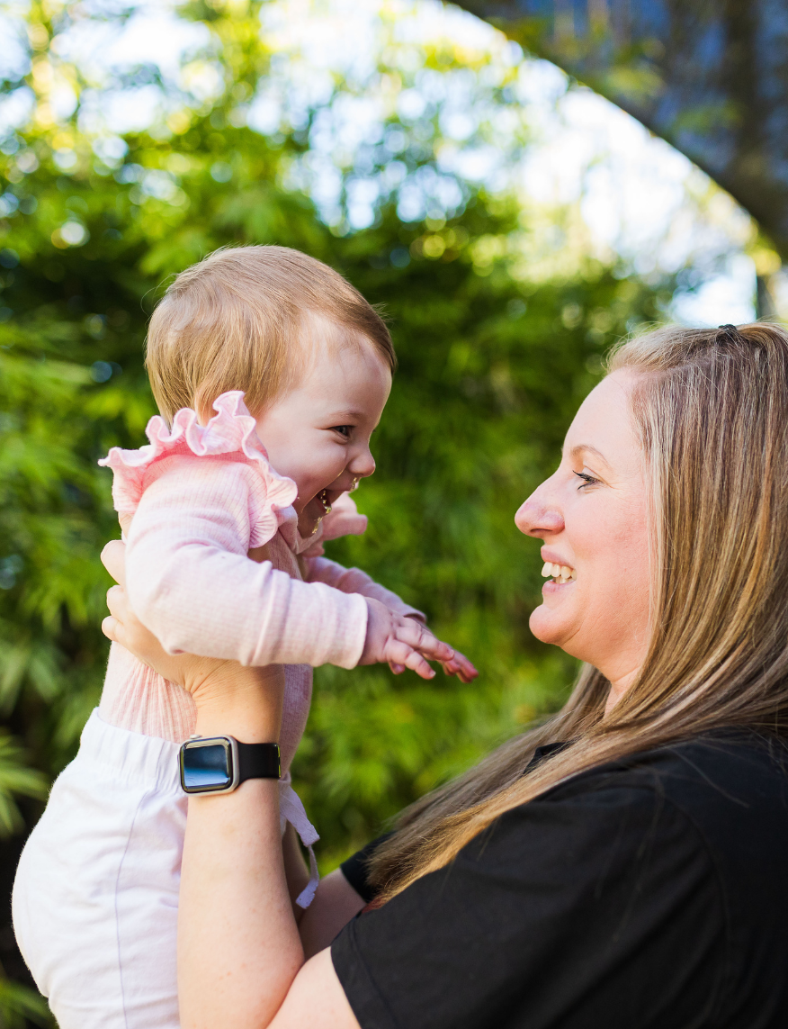 Baby and educator smiling at each other