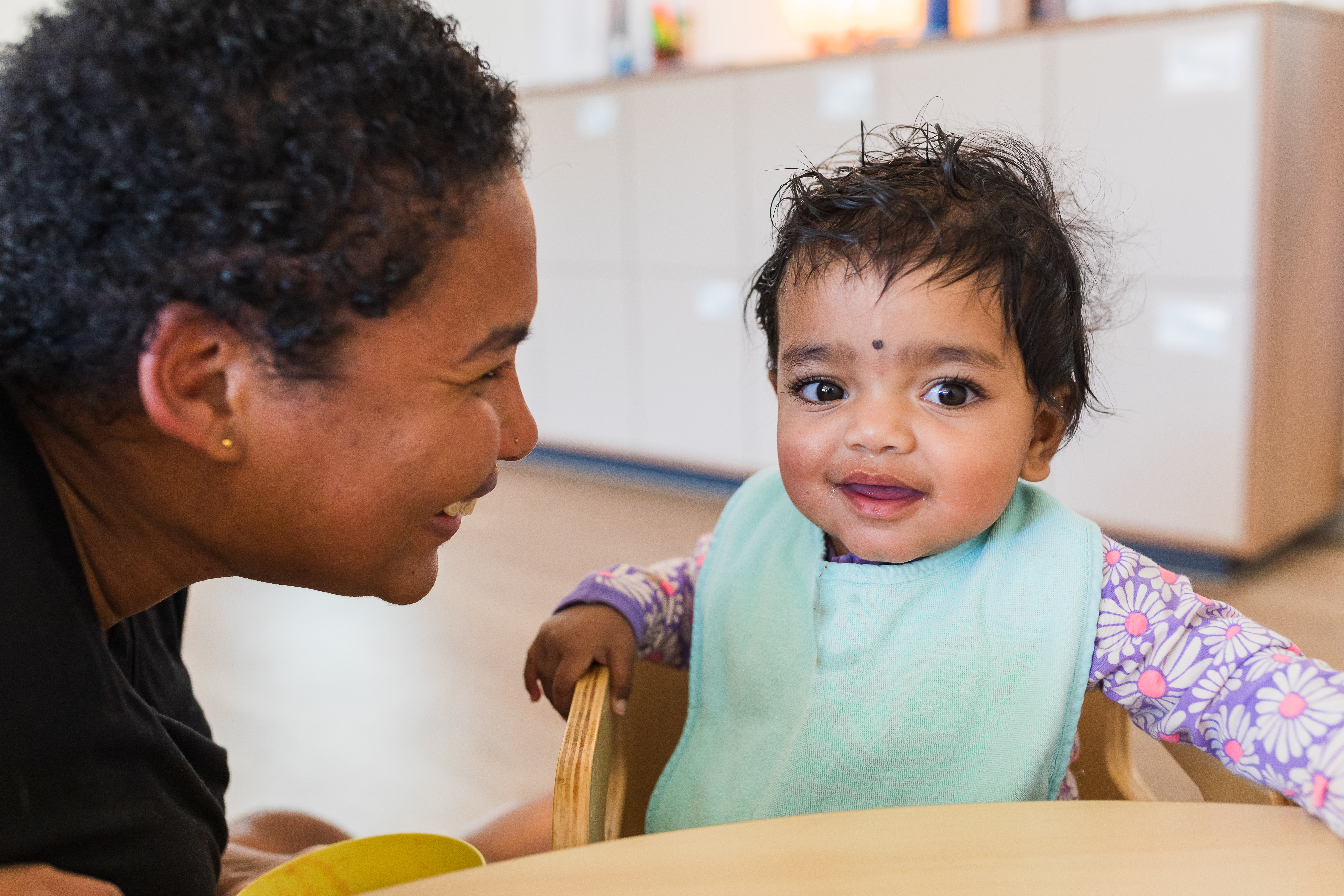 Educator and baby smiling