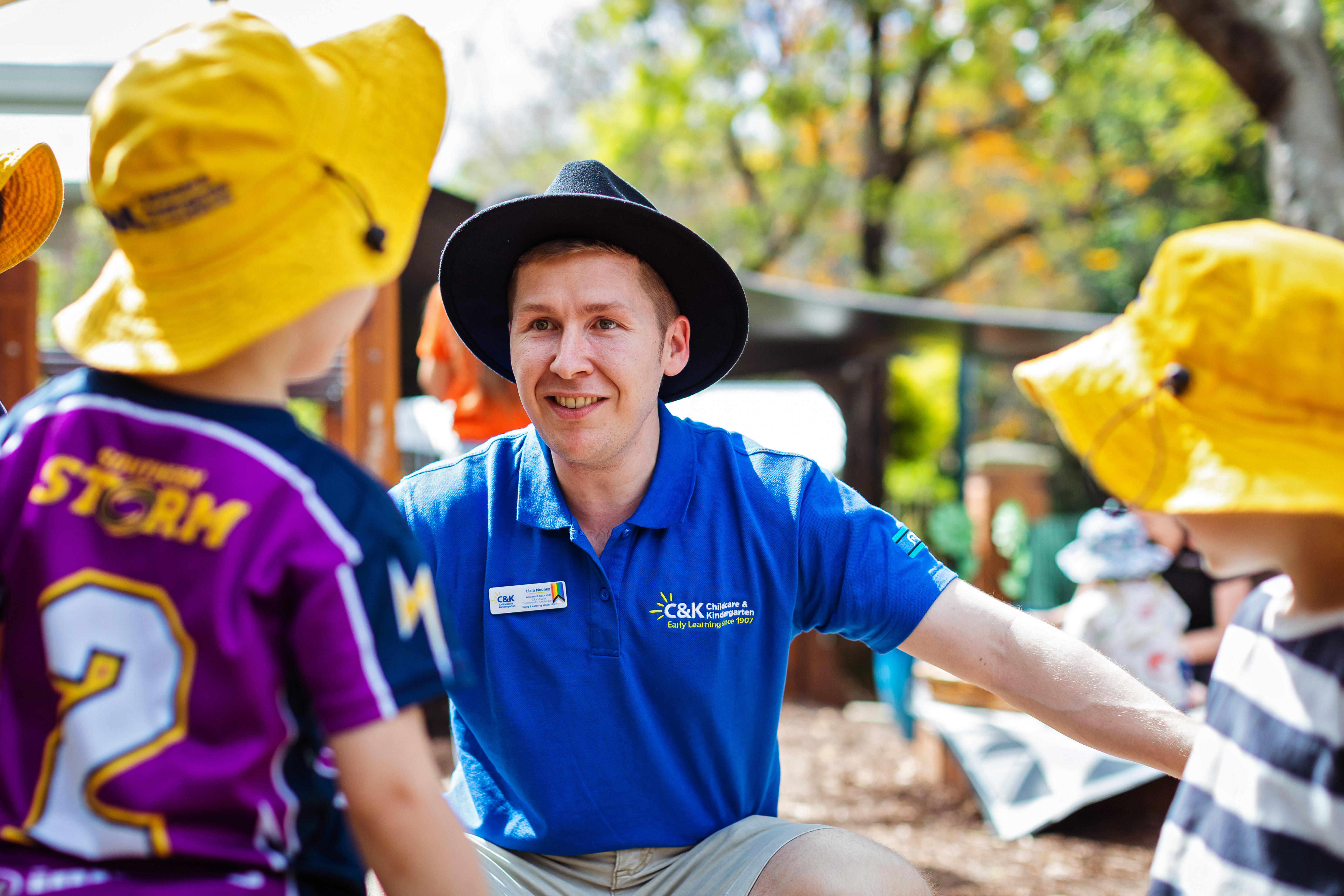 Male educator with two children playing outside