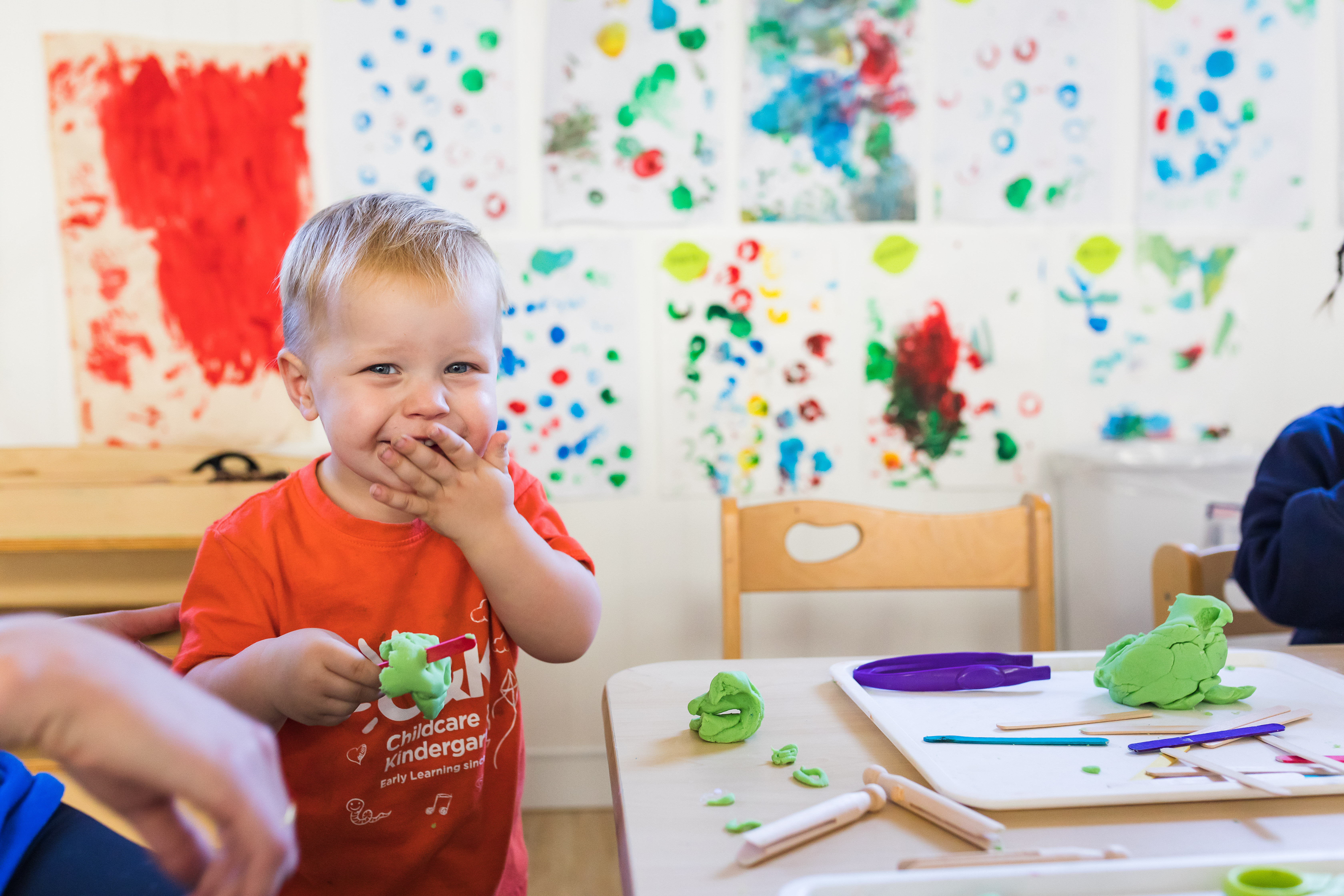 Happy toddler smiling and playing with playdough