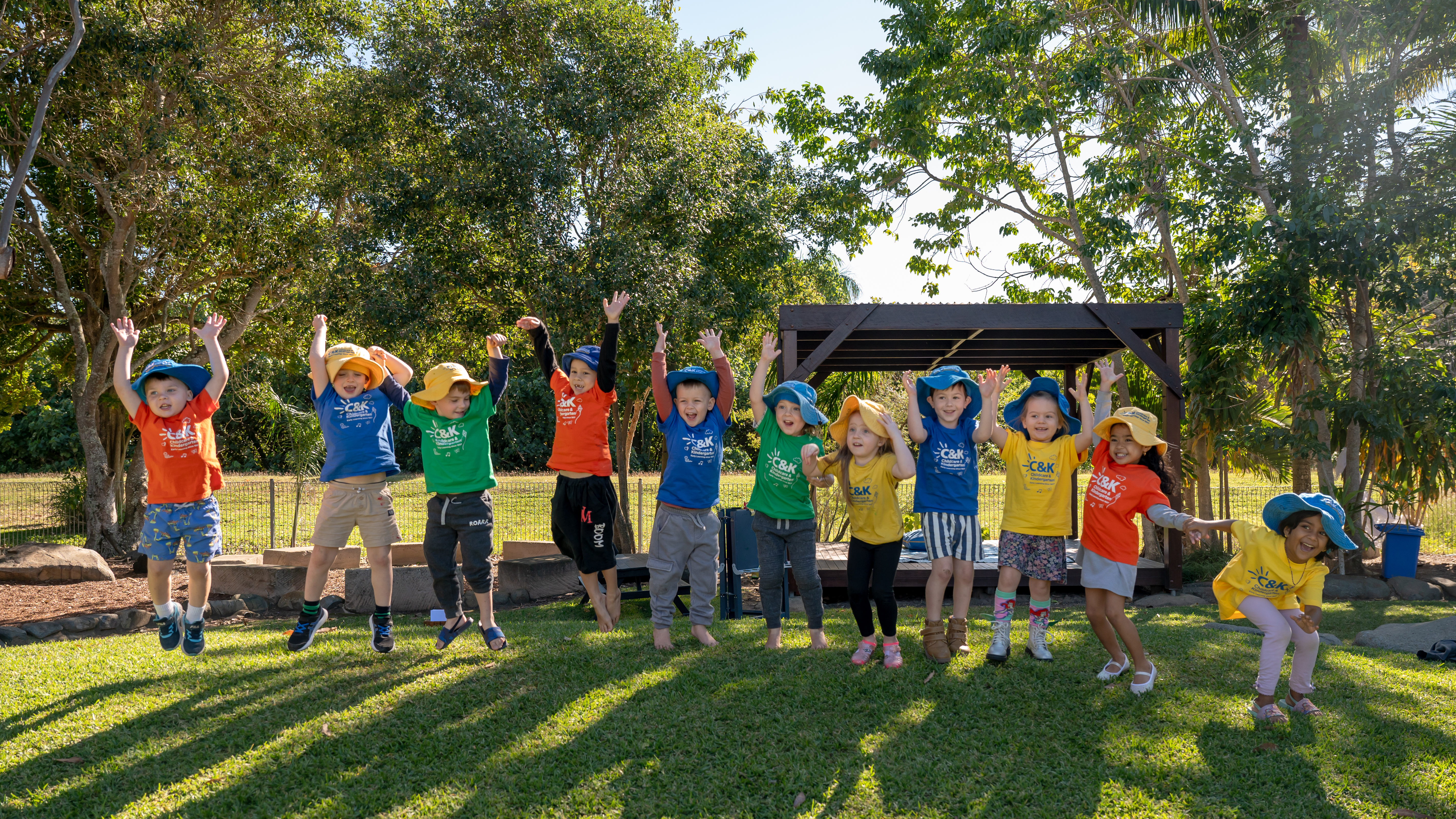 children outside jumping in air smiling